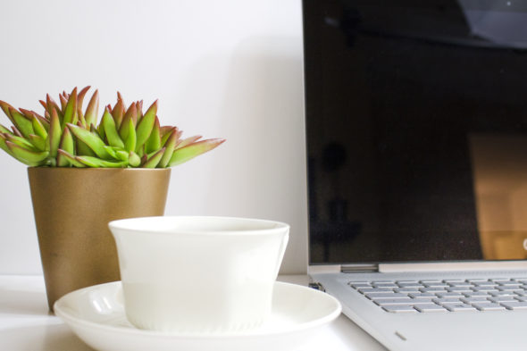 laptop with coffee cup and plant