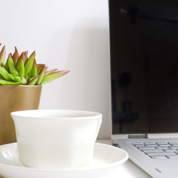 laptop with coffee cup and plant