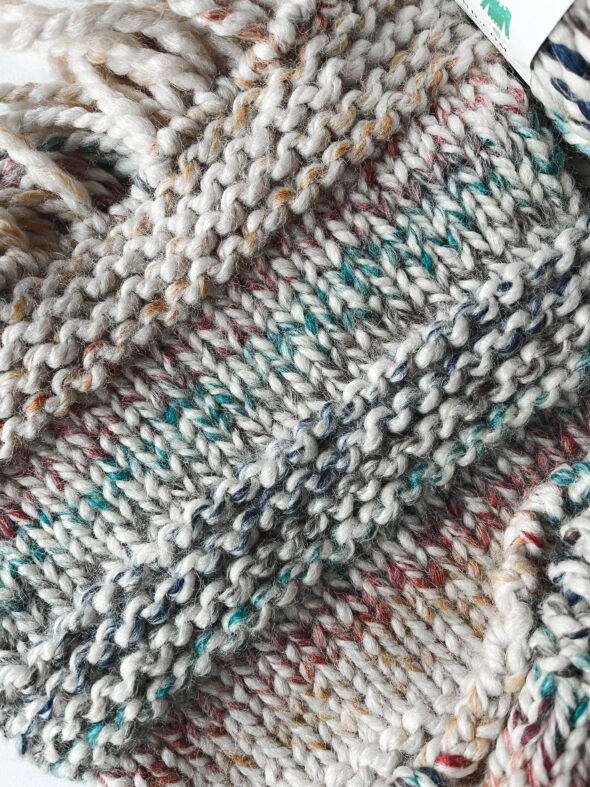 Section of a knitted scarf showing knit and purl stitches